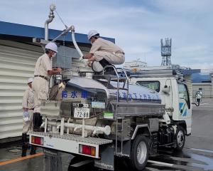 給水車の上から補水する様子