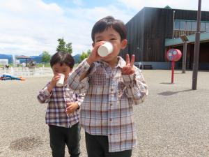 給水車の水を飲む子どもが2人