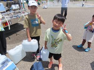 水の入った容器の重さを体験する子ども