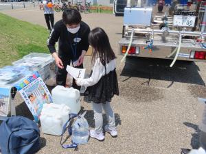 職員からぬりえを受け取る子ども