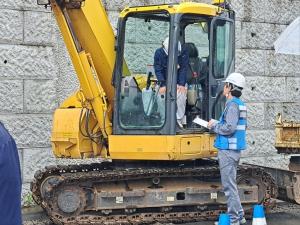 ショベルカーの運転手と話す会員の写真